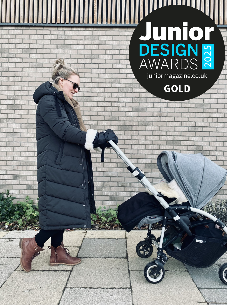 Parent using black hUDOMA pram gloves while pushing a pram, with a Junior Design Awards 2025 Gold badge.
